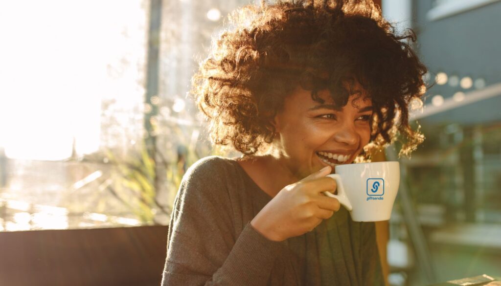 Women drinking coffee from a Giftsenda branded cup